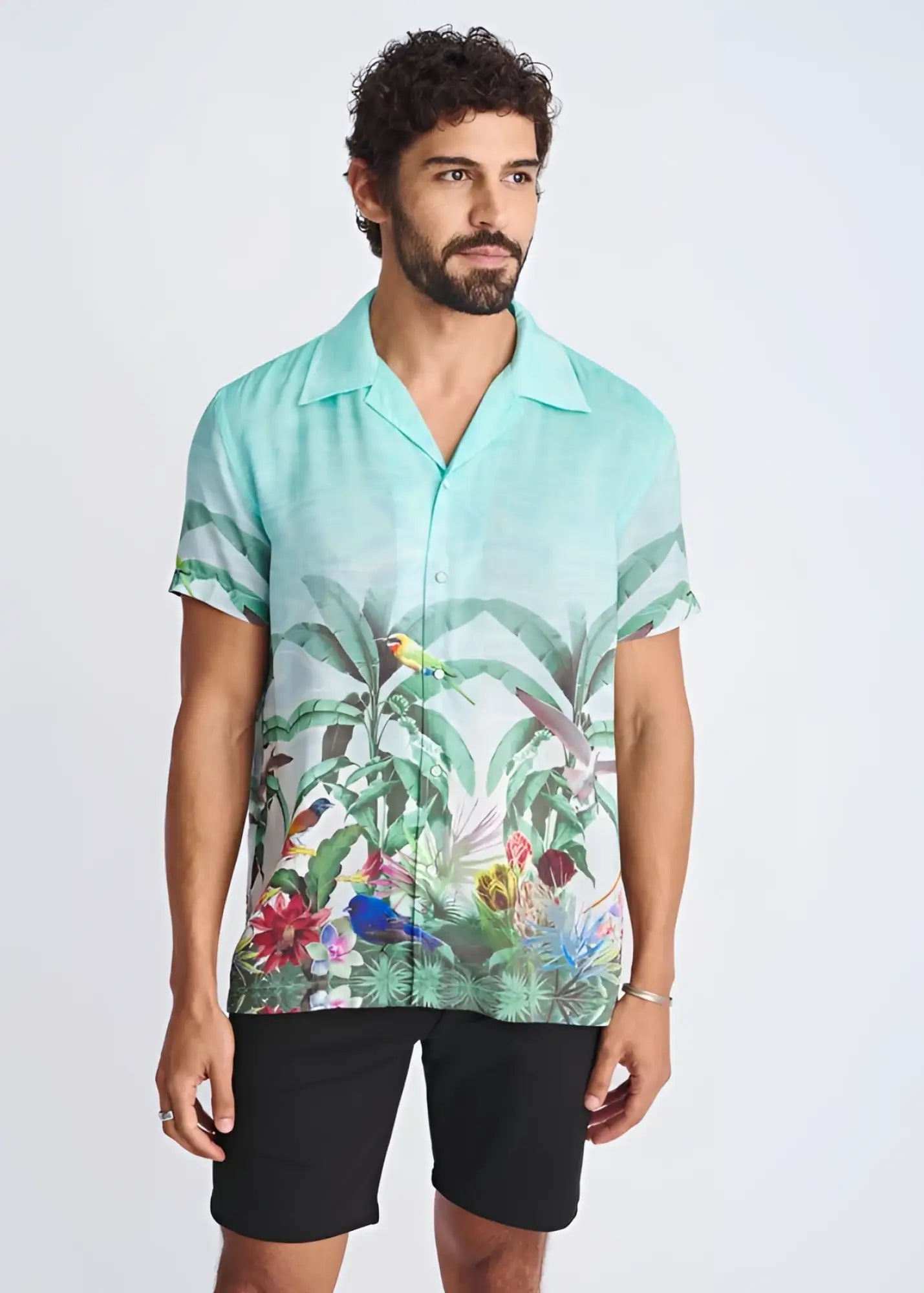 A vibrant turquoise tropics border print short-sleeved modal shirt with tropical birds and lush foliage design