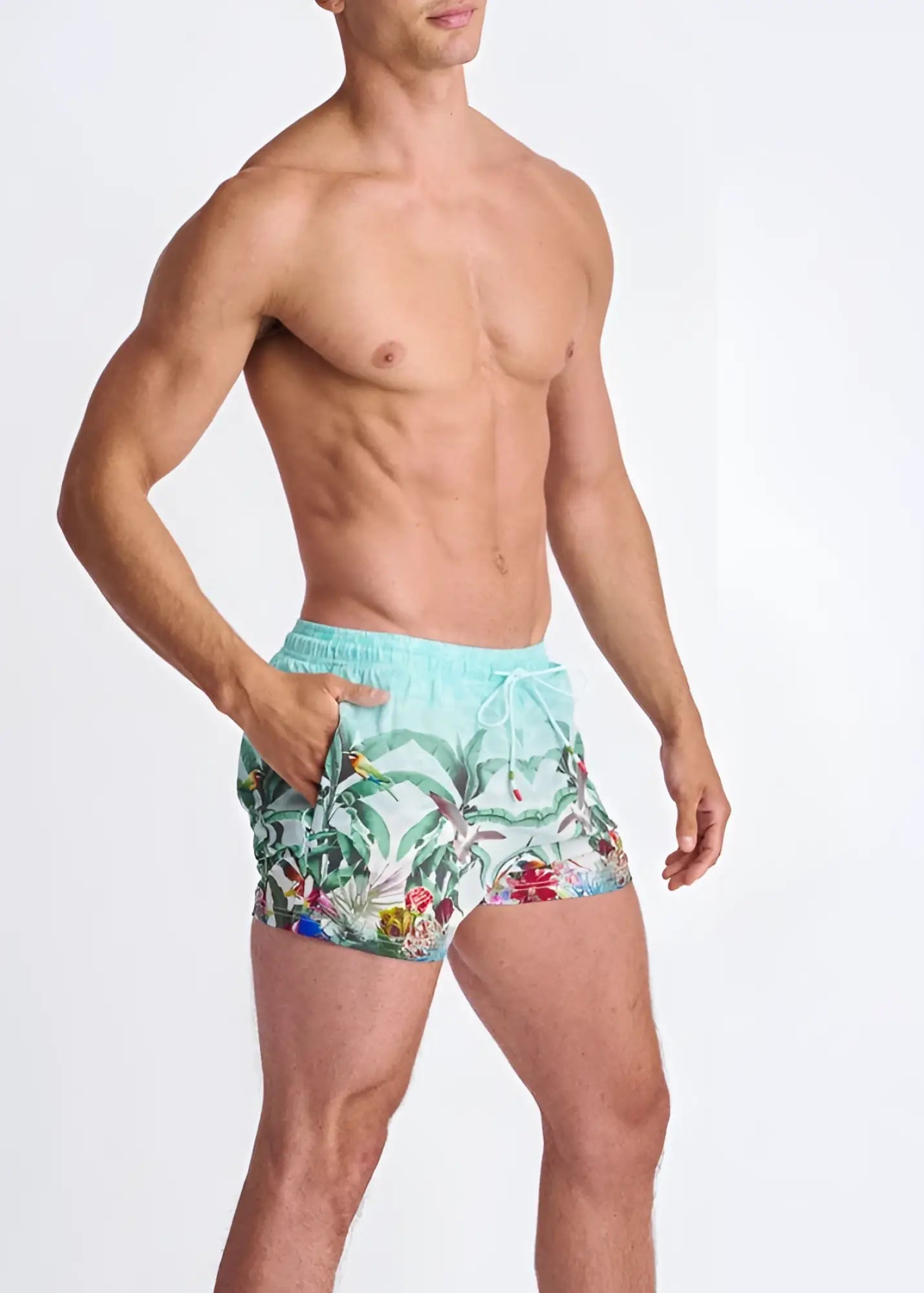 Light blue tropics print swim shorts with mesh lining featuring green leaves red flowers and colorful birds