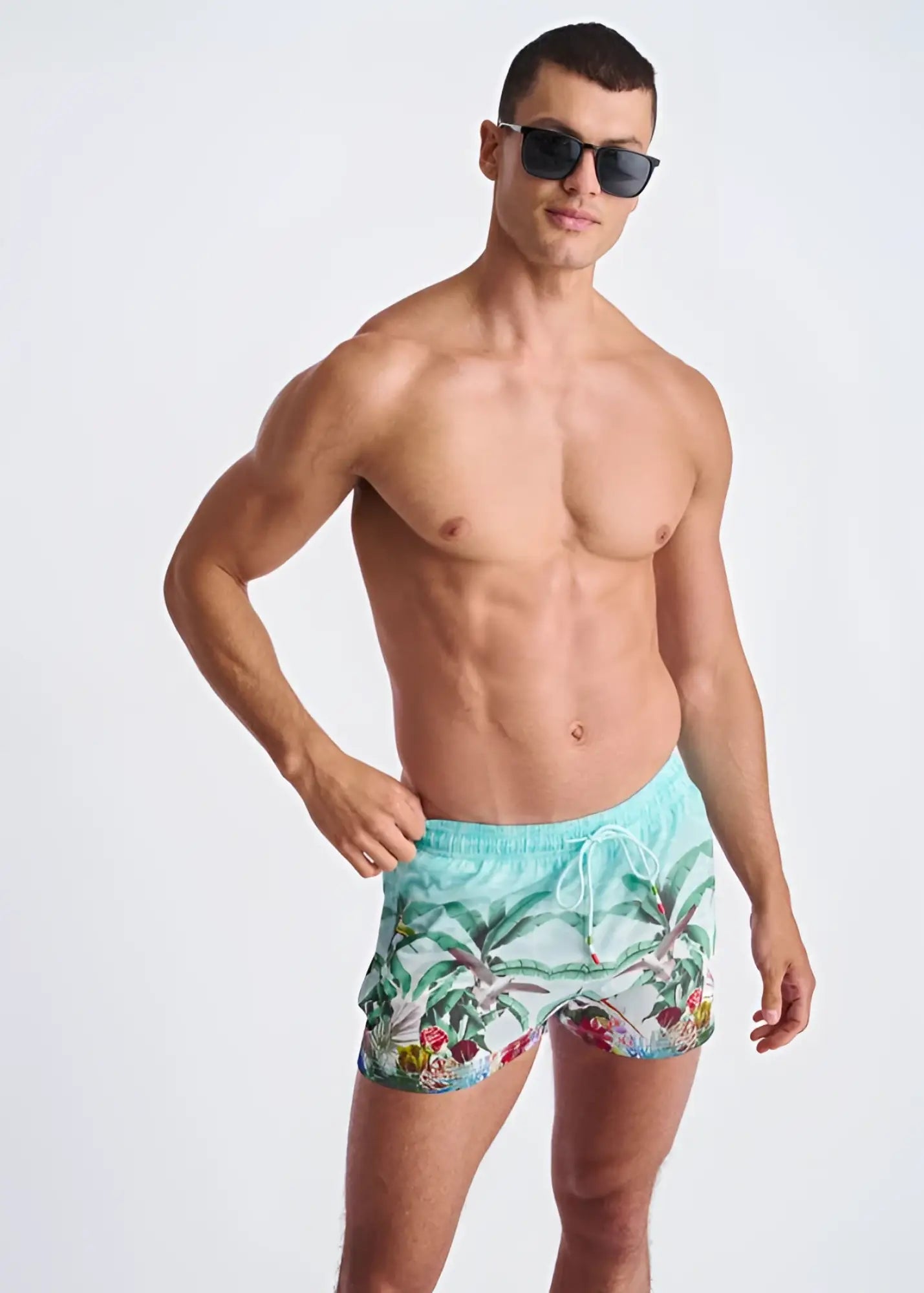 Men’s turquoise tropics print swim shorts with a tropical palm tree and fruit print and mesh lining