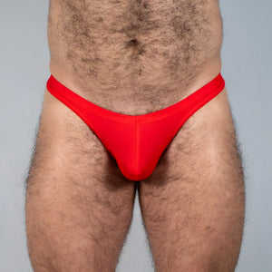 Bright red Tulio swim thong made of smooth stretchy fabric with a form-fitting design shown from the back side