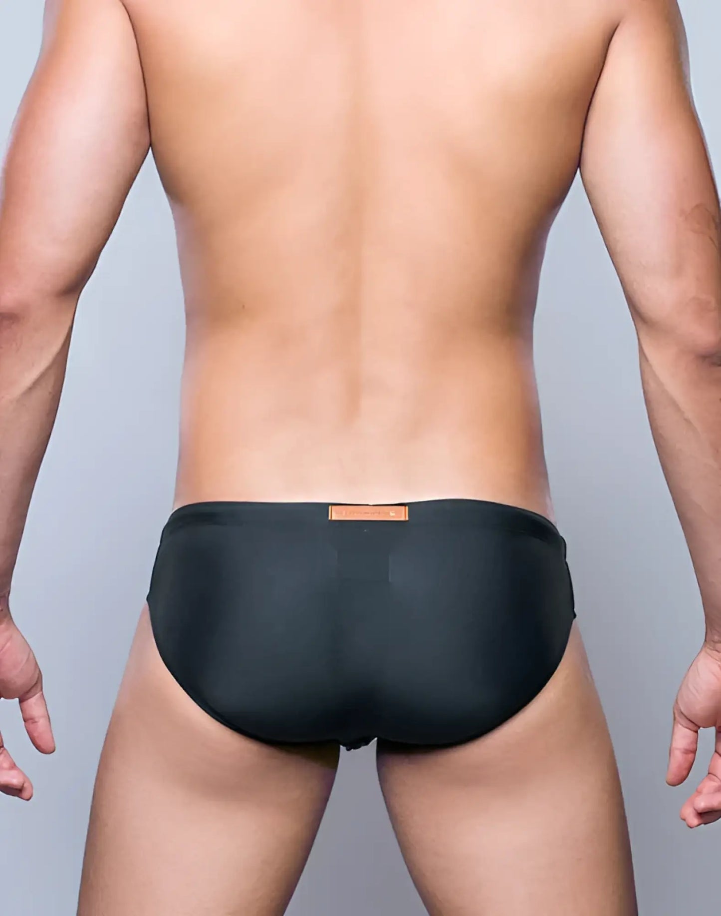 Black V10 core bikini swim trunks with a small orange label at the waistband for swimming and beachwear