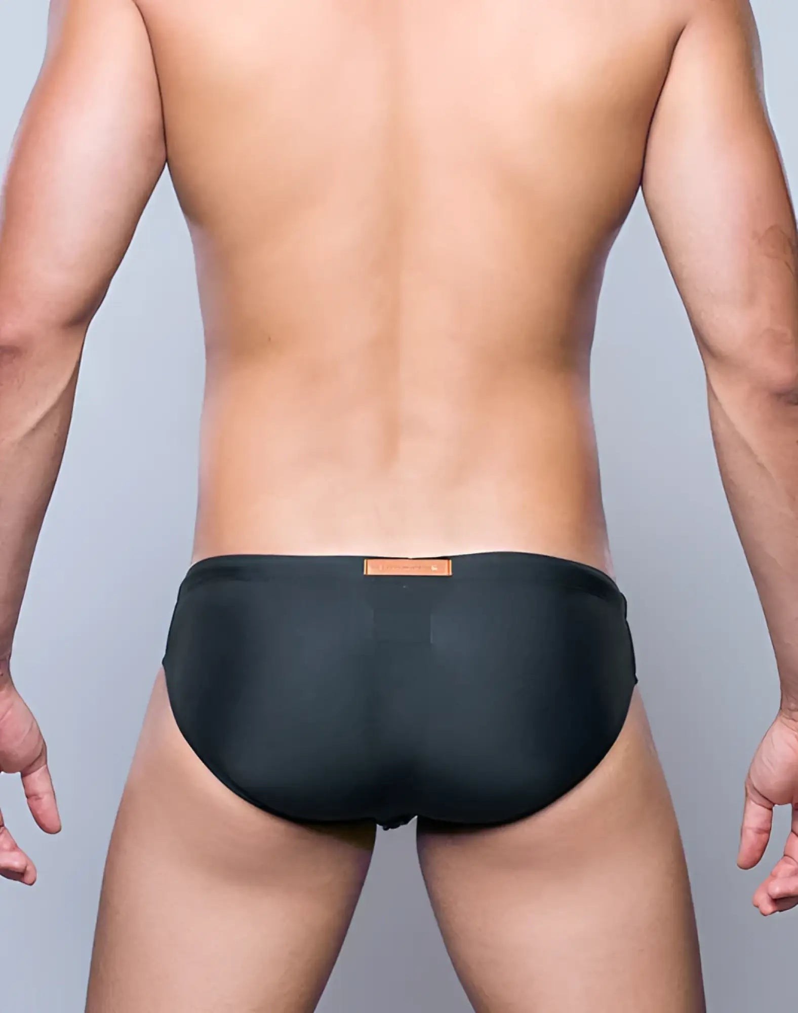 Black V10 core bikini swim trunks with a small orange label at the waistband for swimming and beachwear