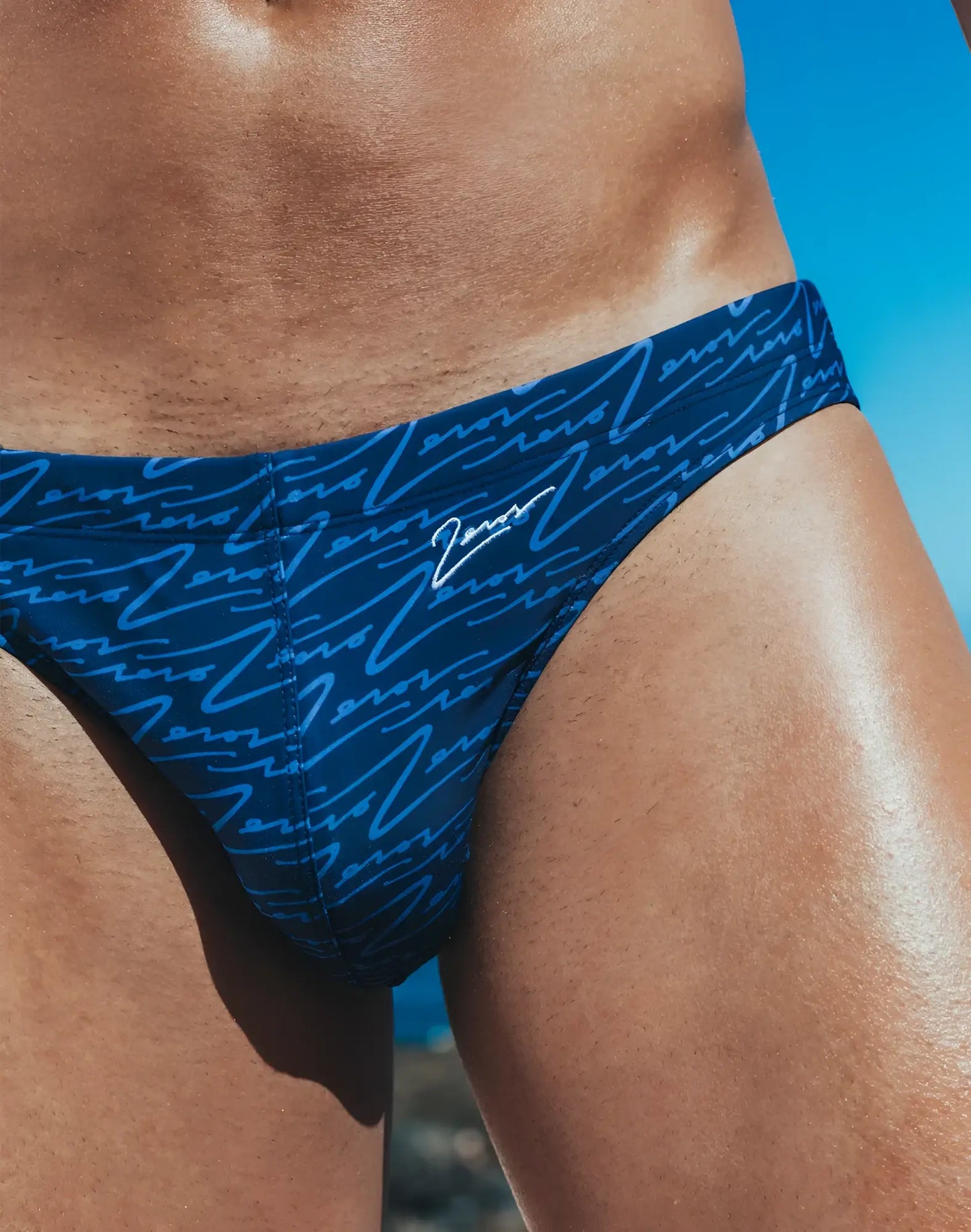 Dark blue v20 signature print swim brief with light blue cursive pattern and white zeros logo on waistband