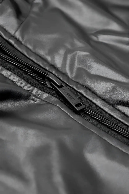 Black vegan leather zipper bodysuit featuring a sleek metallic pull tab on a shiny quilted jacket panel