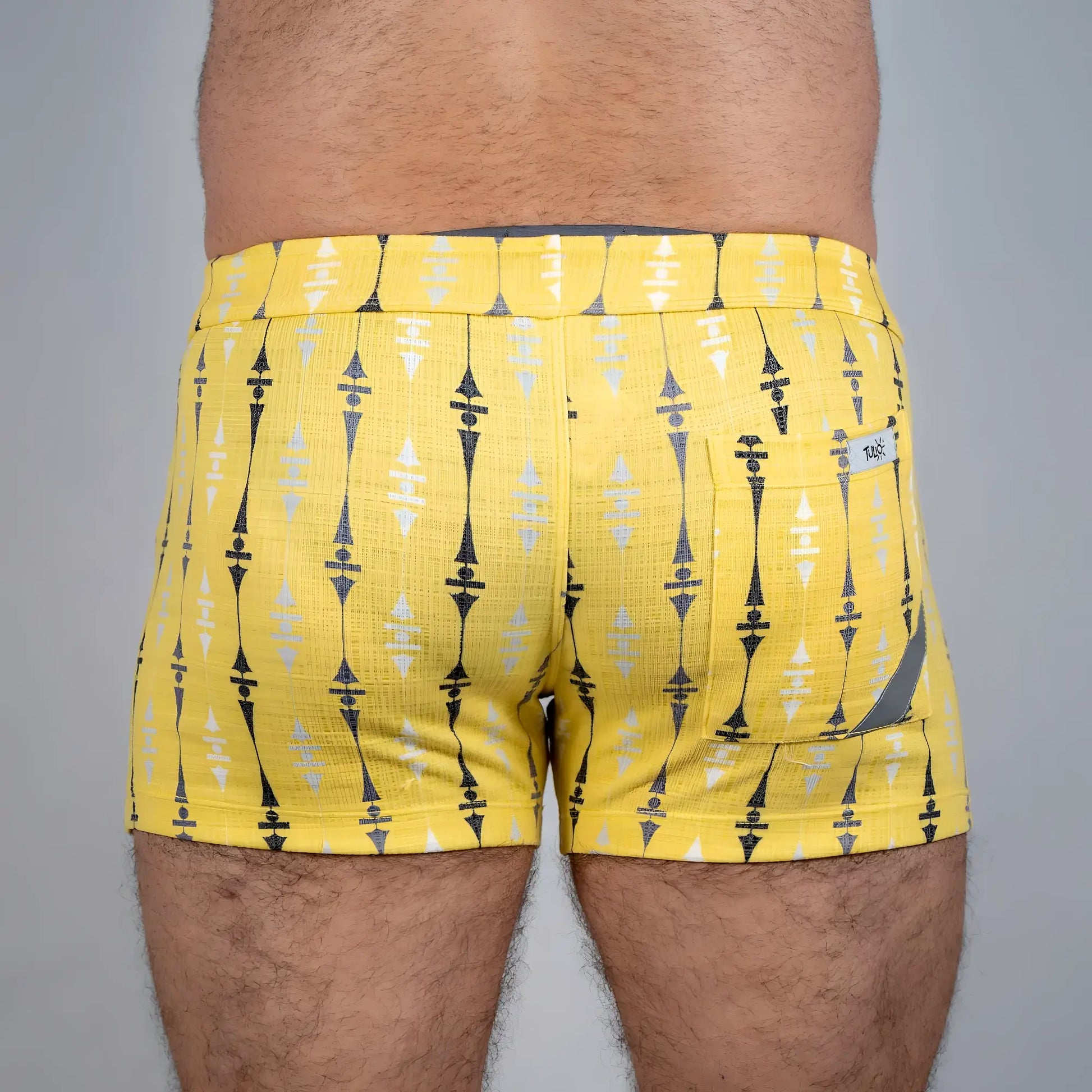 Bright yellow wallpaper print linen texture shorts with bold black and white geometric pattern and branded back pocket tag