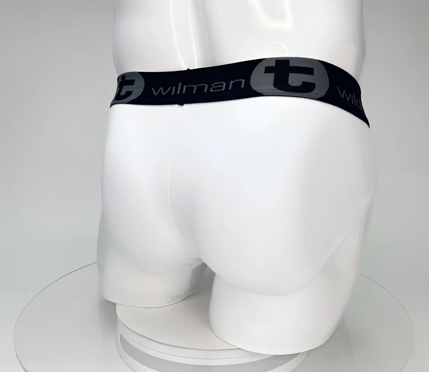 White cotton WildmanT big boy pouch briefs with black elastic waistband featuring wilman brand name and logo