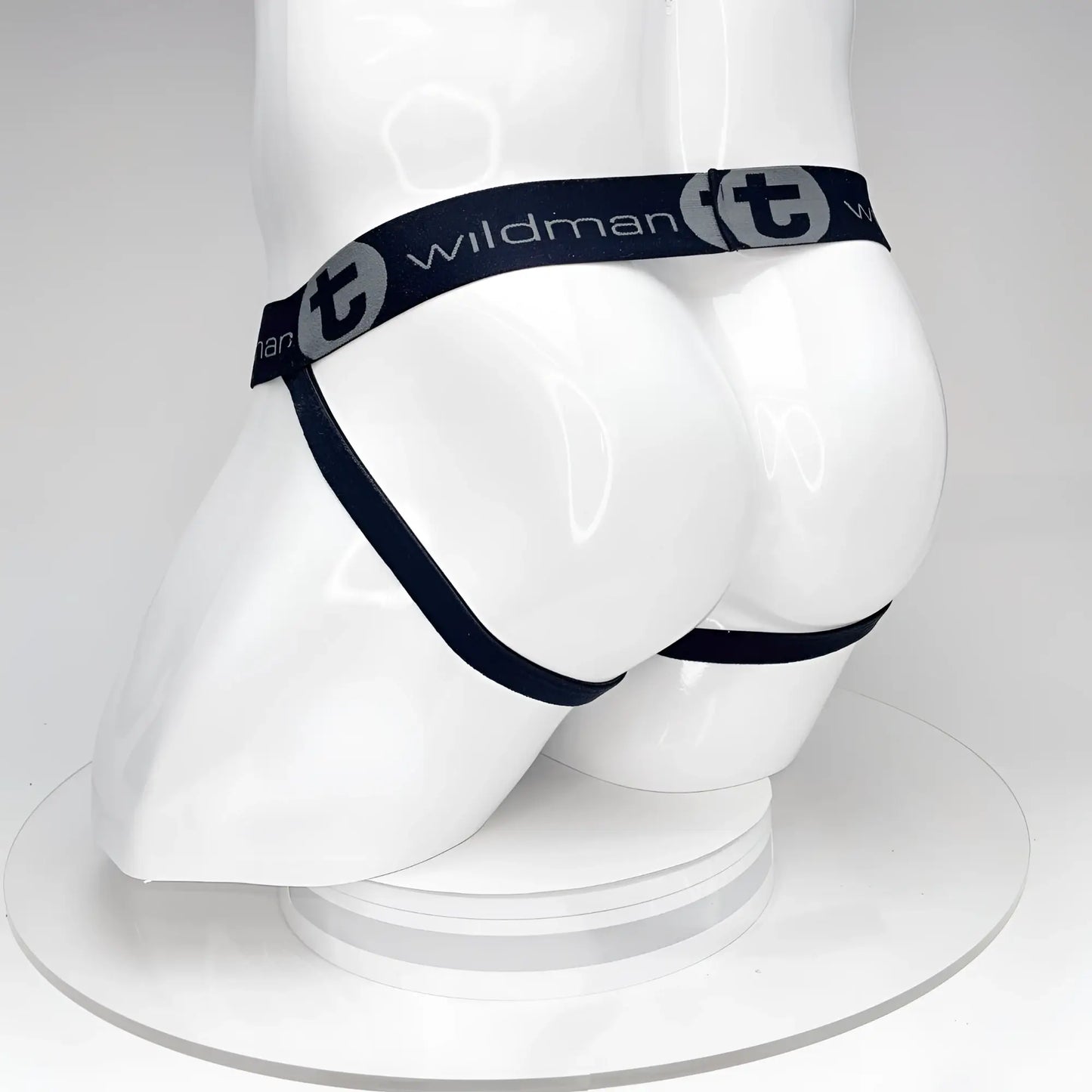 Black WildmanT jockstrap on a white mannequin, featuring a branded elastic waistband with logo text and side straps.