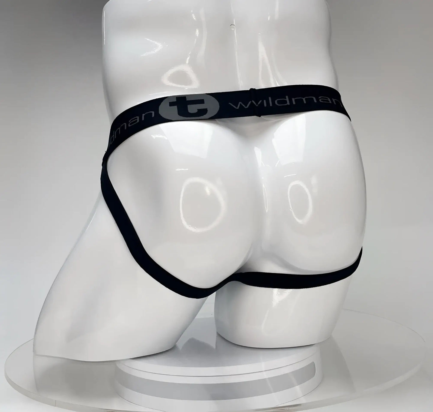 Black elastic waistband briefs with wildman branding on white mannequin for wildmant big boy pouch jockstrap white product