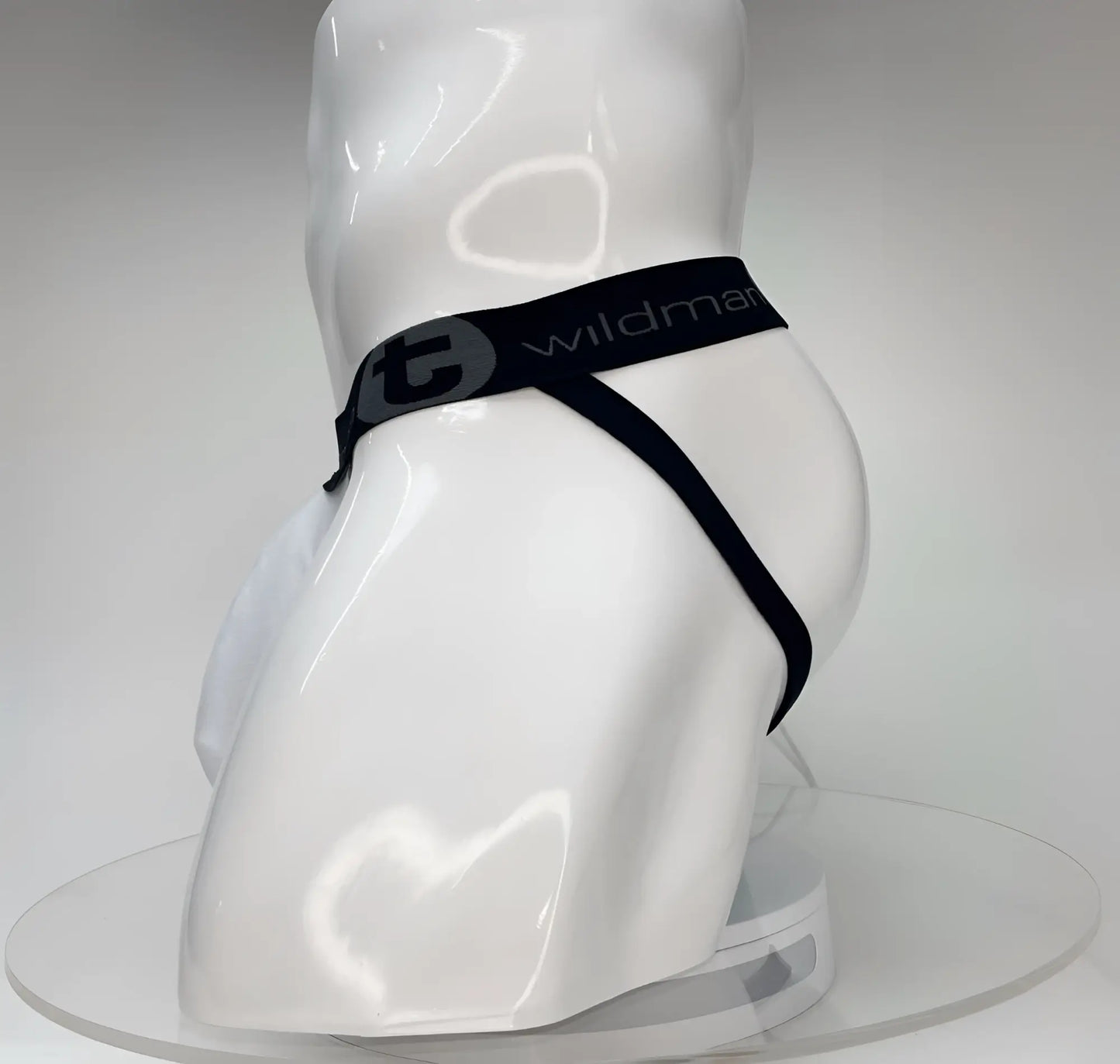 White WildmanT Big Boy pouch jockstrap on a mannequin, featuring a black branded waistband with a circular logo.