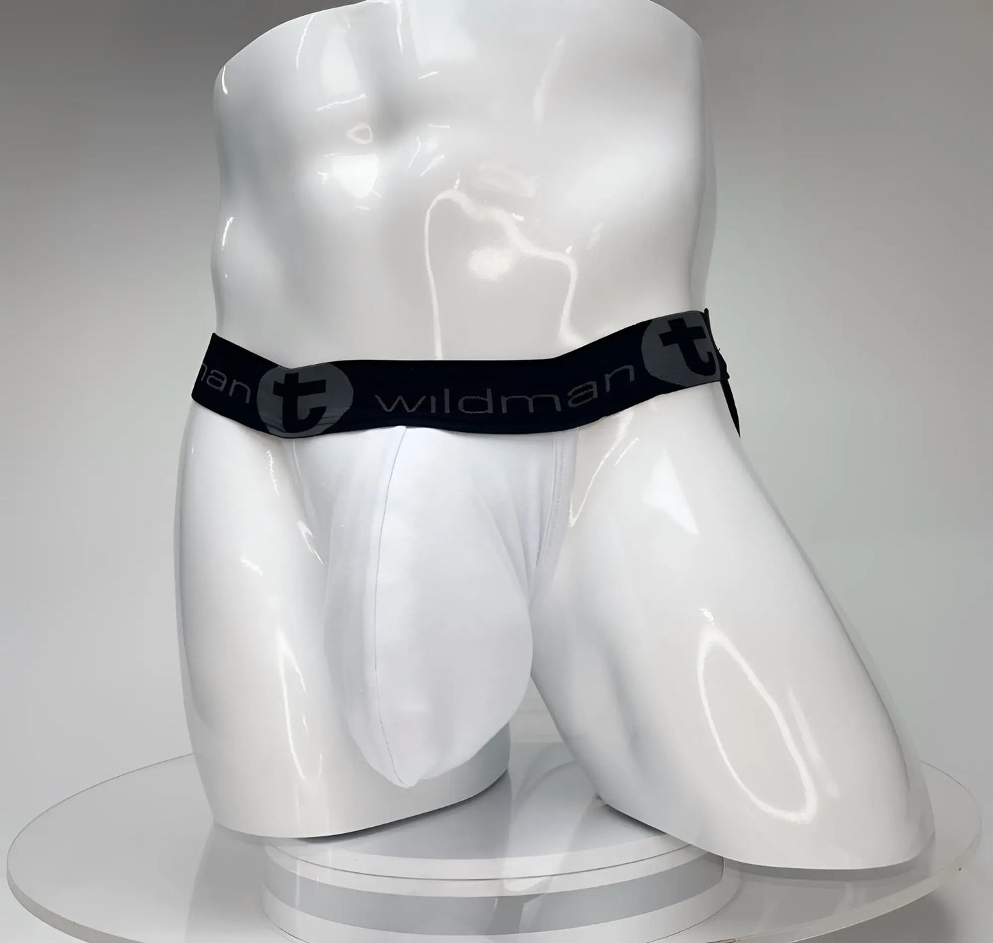 White WildmanT Big Boy pouch jockstrap on a mannequin, featuring a black waistband with WildmanT logo branding.