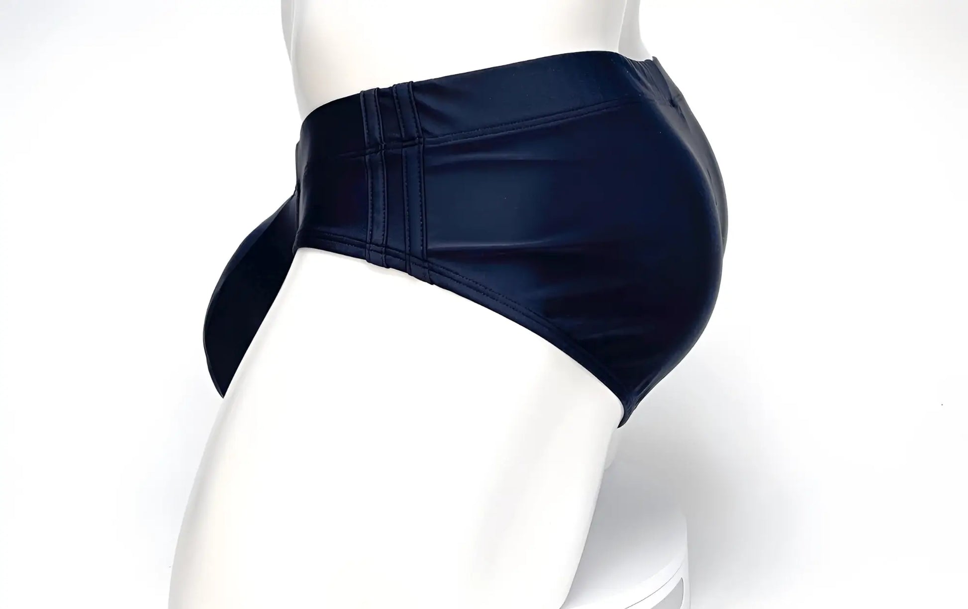 Side view of black WildmanT Big Boy Pouch swim briefs on a mannequin, featuring reinforced side panels.
