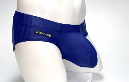 WildmanT navy blue swim brief with a prominent contoured pouch and side logo tag, modeled on a white mannequin.