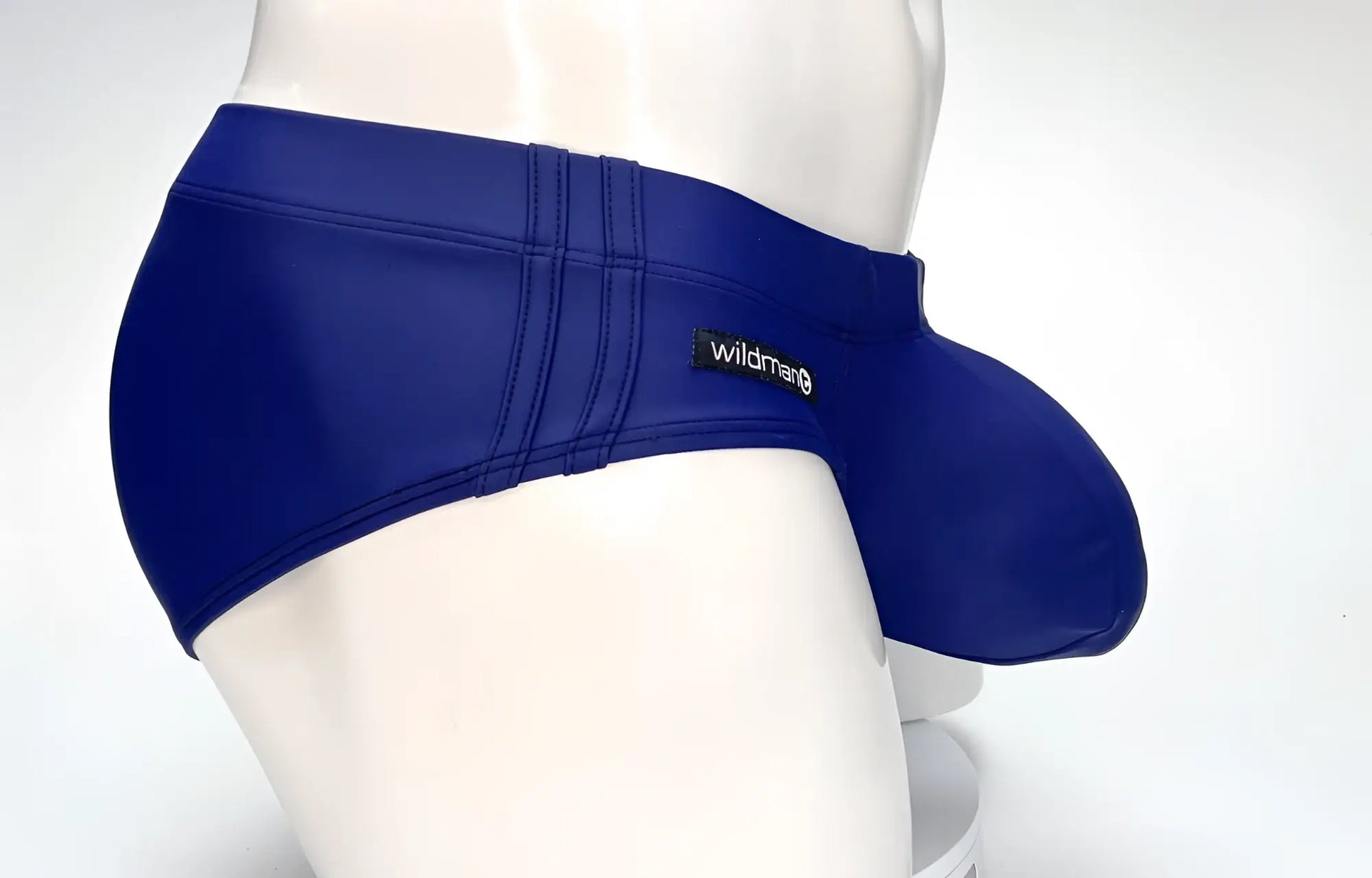 Side view of a navy blue WildmanT swim brief with a large front pouch and double-stitched side panels on a mannequin.