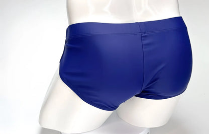 Rear view of navy blue WildmanT Big Boy swim brief on a white mannequin.