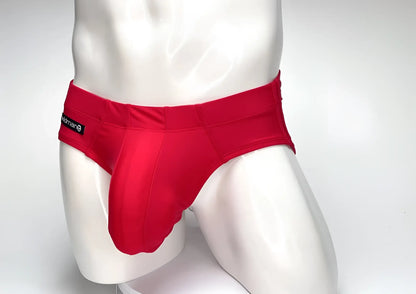 WildmanT Big Boy pouch swim brief in solid red on a mannequin, featuring a prominent front pouch and side logo tab.