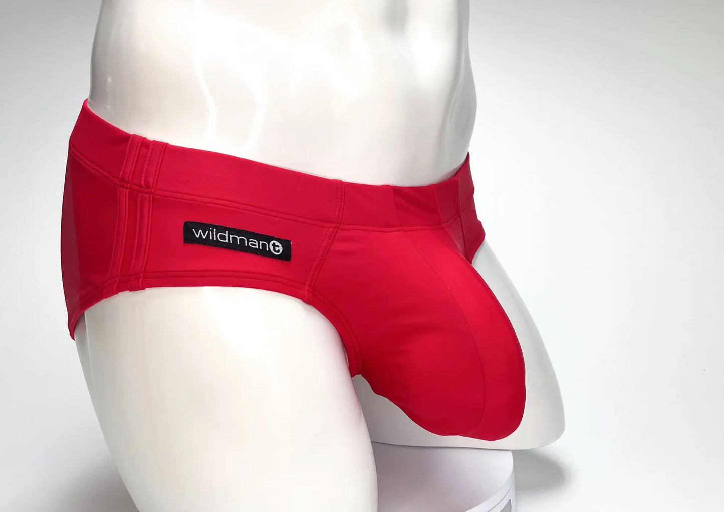 Red wildman big boy pouch swim brief swim trunks on mannequin featuring bold red fabric and ergonomic design