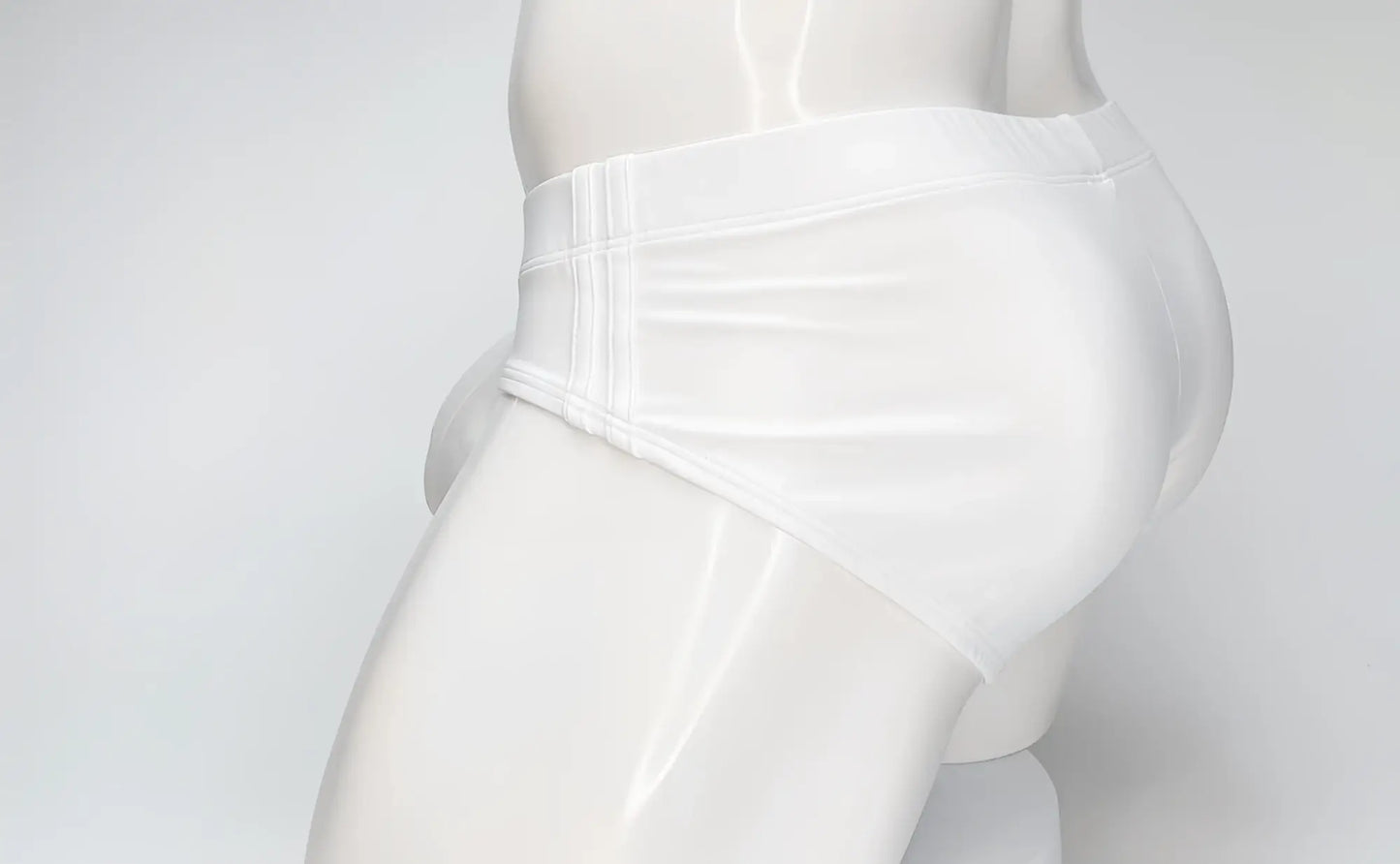 White WildmanT Big Boy pouch swim brief worn by a mannequin, shown from a side profile view.