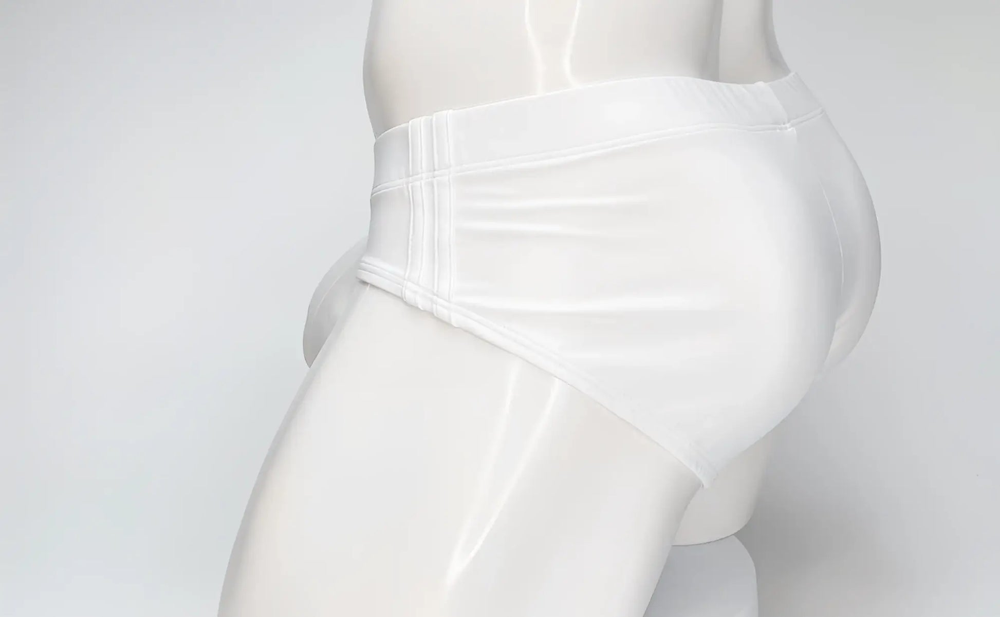 White WildmanT Big Boy pouch swim brief worn by a mannequin, shown from a side profile view.