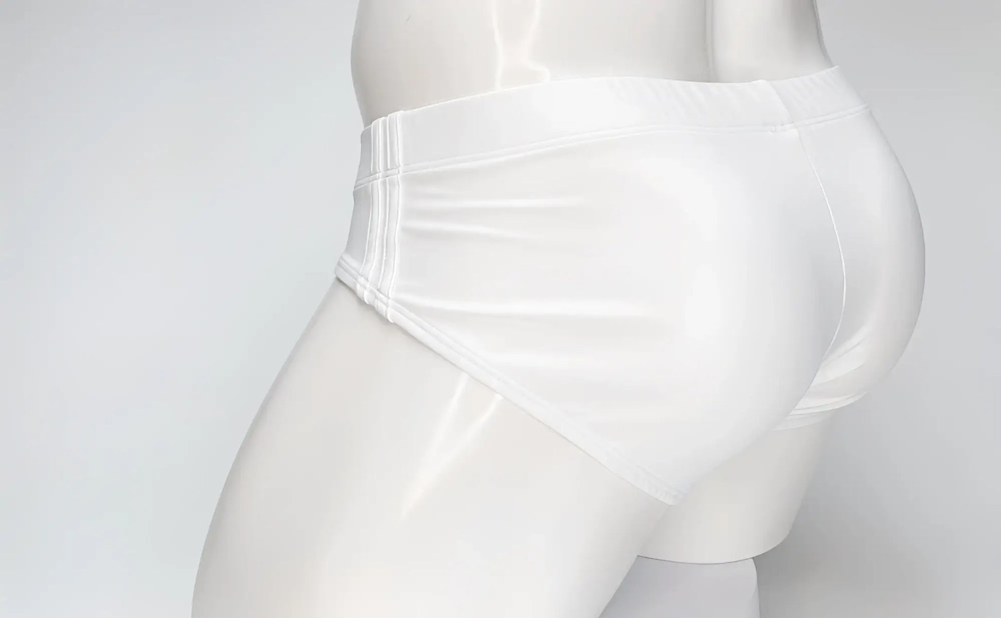 Side view of a white WildmanT Big Boy swim brief on a white mannequin, featuring stitched side panel detailing.