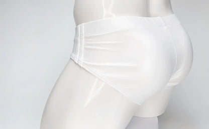 Side view of a white WildmanT Big Boy swim brief on a white mannequin, featuring stitched side panel detailing.