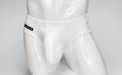 White WildmanT Big Boy pouch swim brief on a white mannequin with a branded black logo patch on the side.