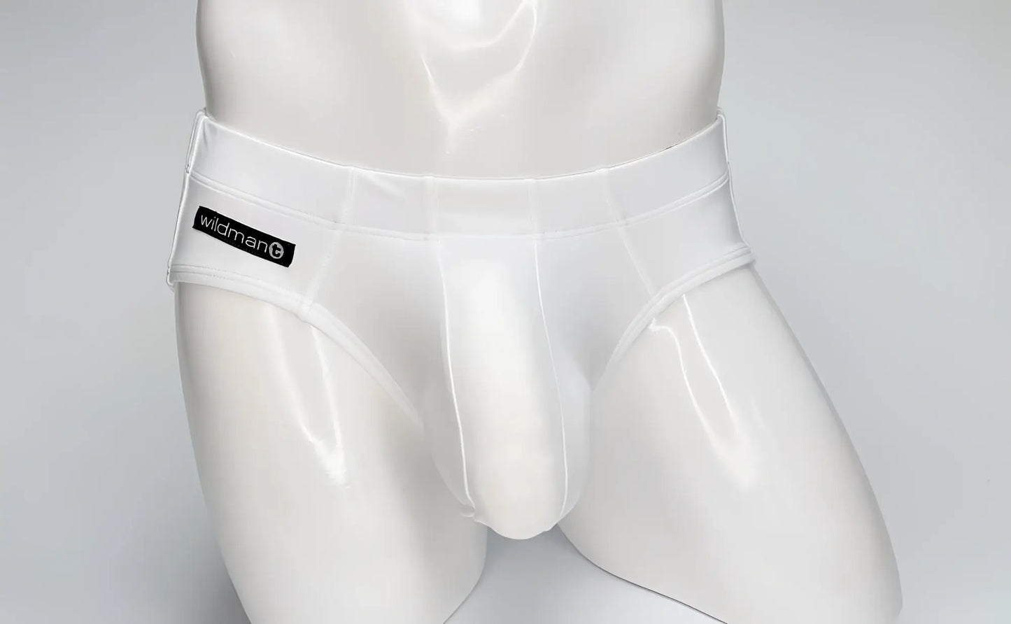 WildmanT white Big Boy pouch swim brief on a mannequin, featuring a black branded logo patch on the right hip.