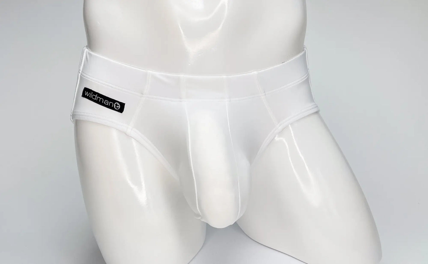 White glossy latex swim briefs with black wildman brand label on waistband wildmant big boy pouch style