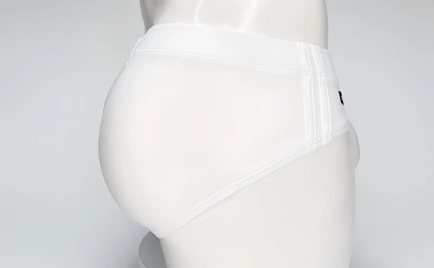 White WildmanT swim brief on a mannequin, featuring a contoured pouch design and side-stitched detailing.