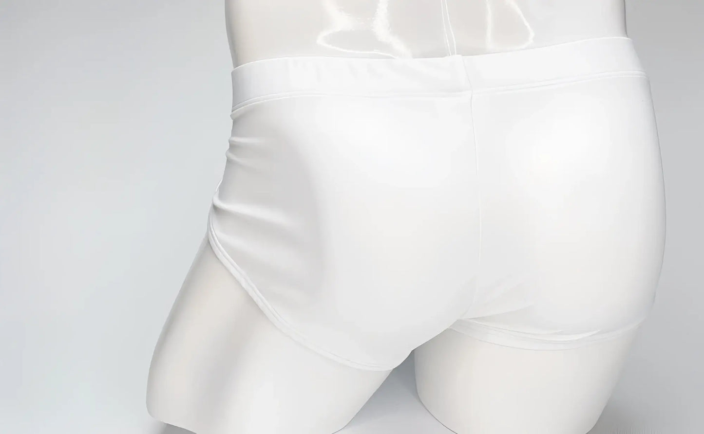 Back view of a white WildmanT Big Boy Pouch swim brief on a white mannequin torso.