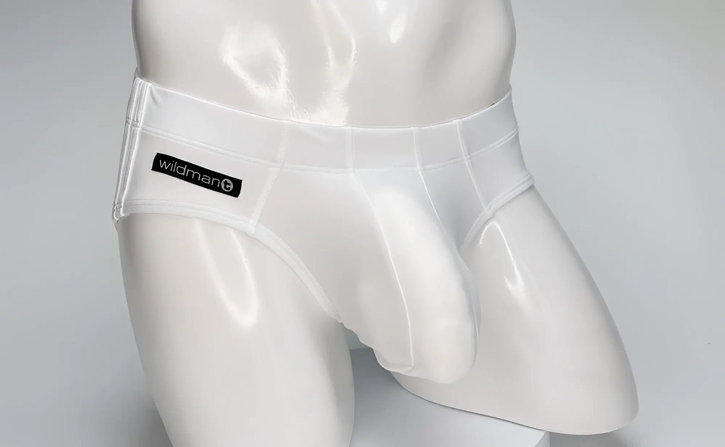 White WildmanT swim brief on a mannequin, featuring a contoured front pouch and a black branded label on the hip.