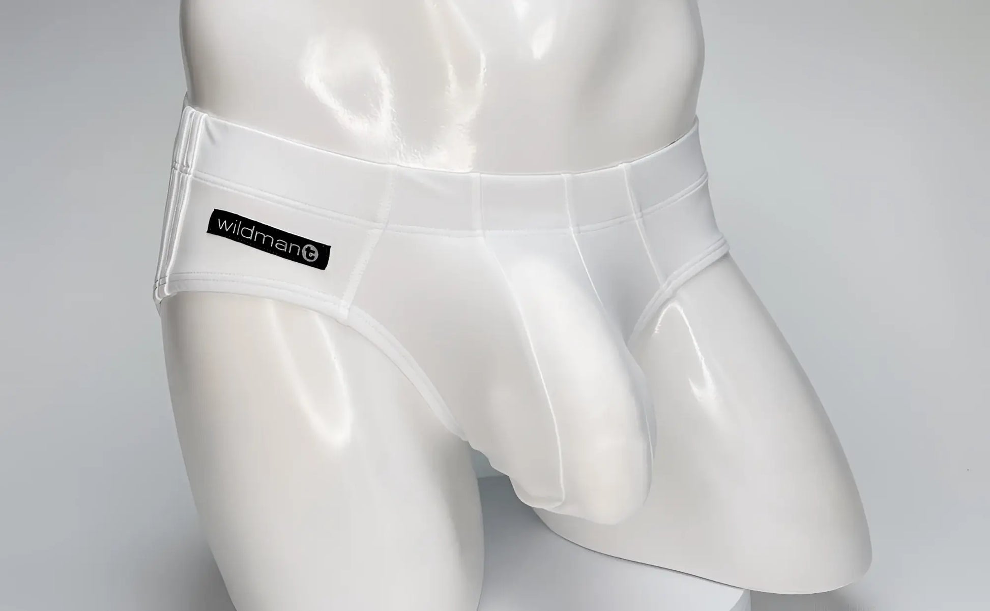 White WildmanT swim brief on a mannequin, featuring a contoured front pouch and a black branded label on the hip.