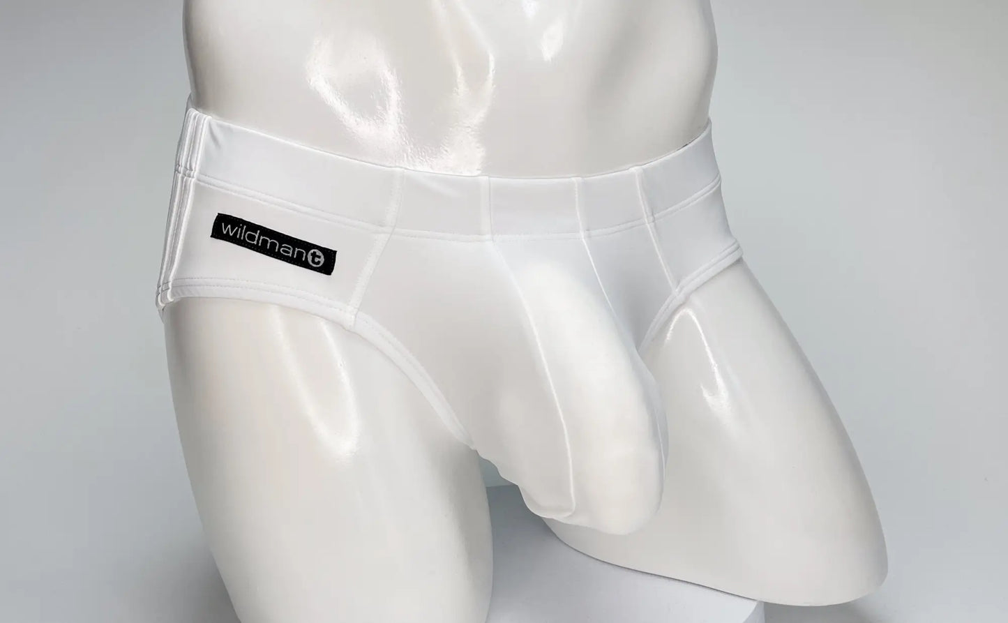 Wildmant big boy pouch swim brief in white translucent latex with black wildman brand label on waistband