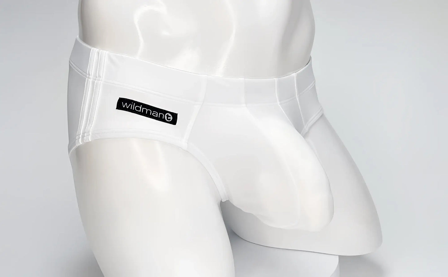 White WildmanT Big Boy pouch swim brief worn by a white mannequin, featuring a branded black logo patch.