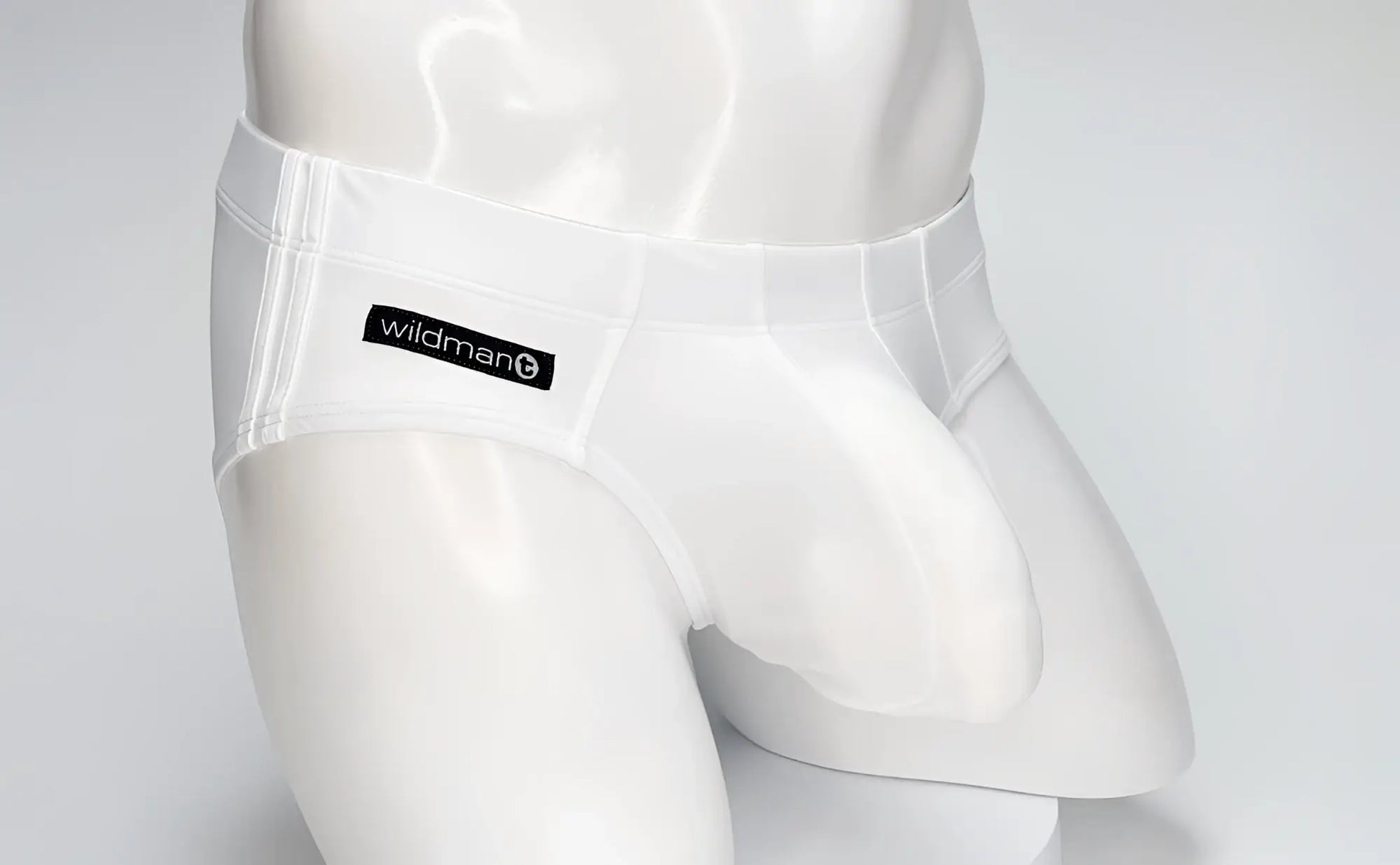 White WildmanT Big Boy pouch swim brief worn by a white mannequin, featuring a branded black logo patch.