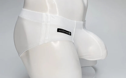 White WildmanT swim brief with a large front pouch and black branded tag, worn by a white mannequin torso.