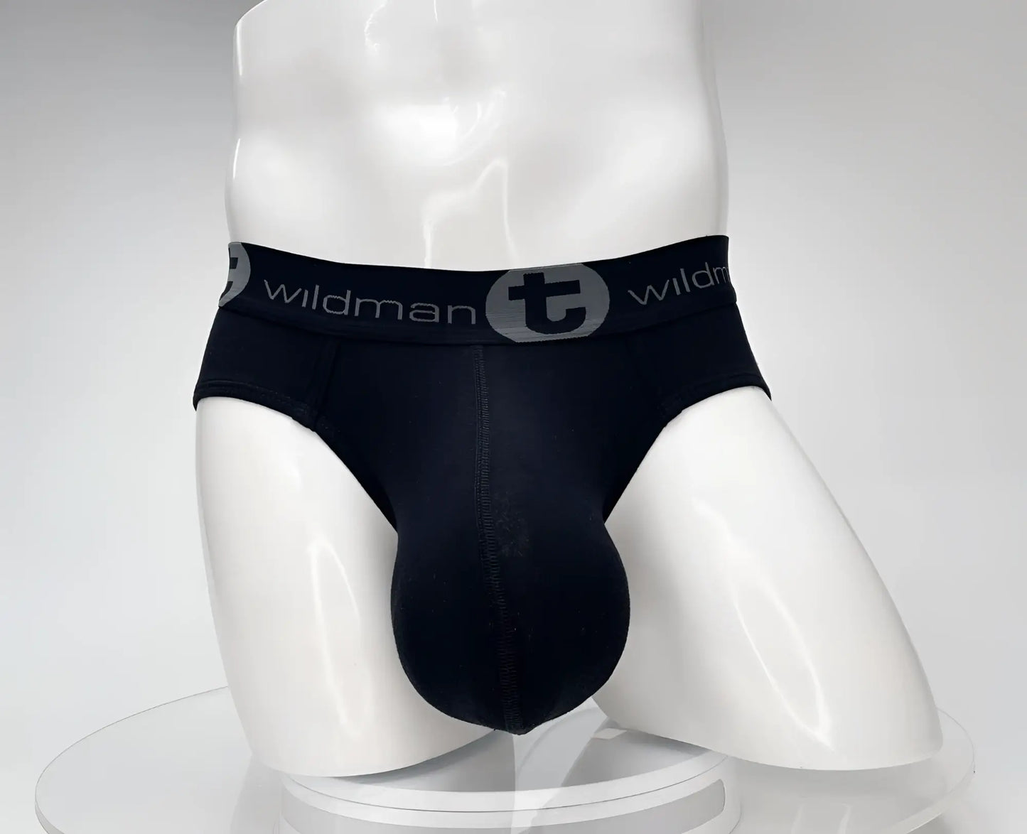 Black men’s cotton briefs with gray elastic waistband featuring wildman logo and circular emblem in wildmant cotton monster cock brief black