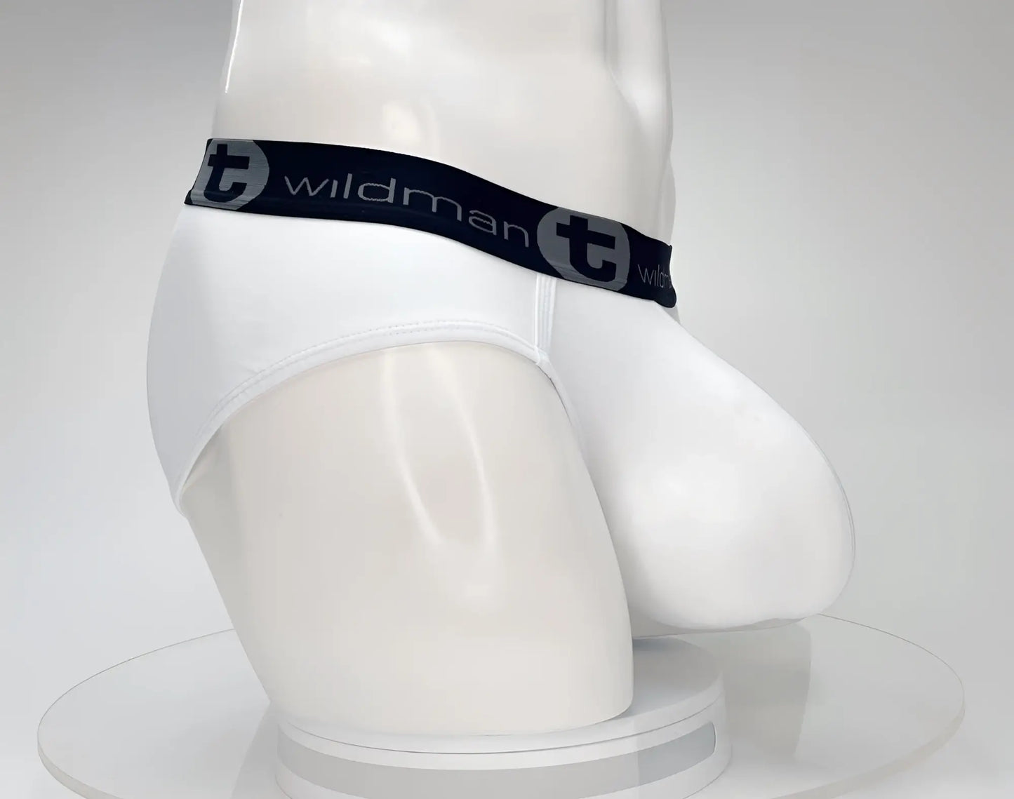 White men’s cotton brief with wildman brand logo and black elastic waistband featuring circular t emblem