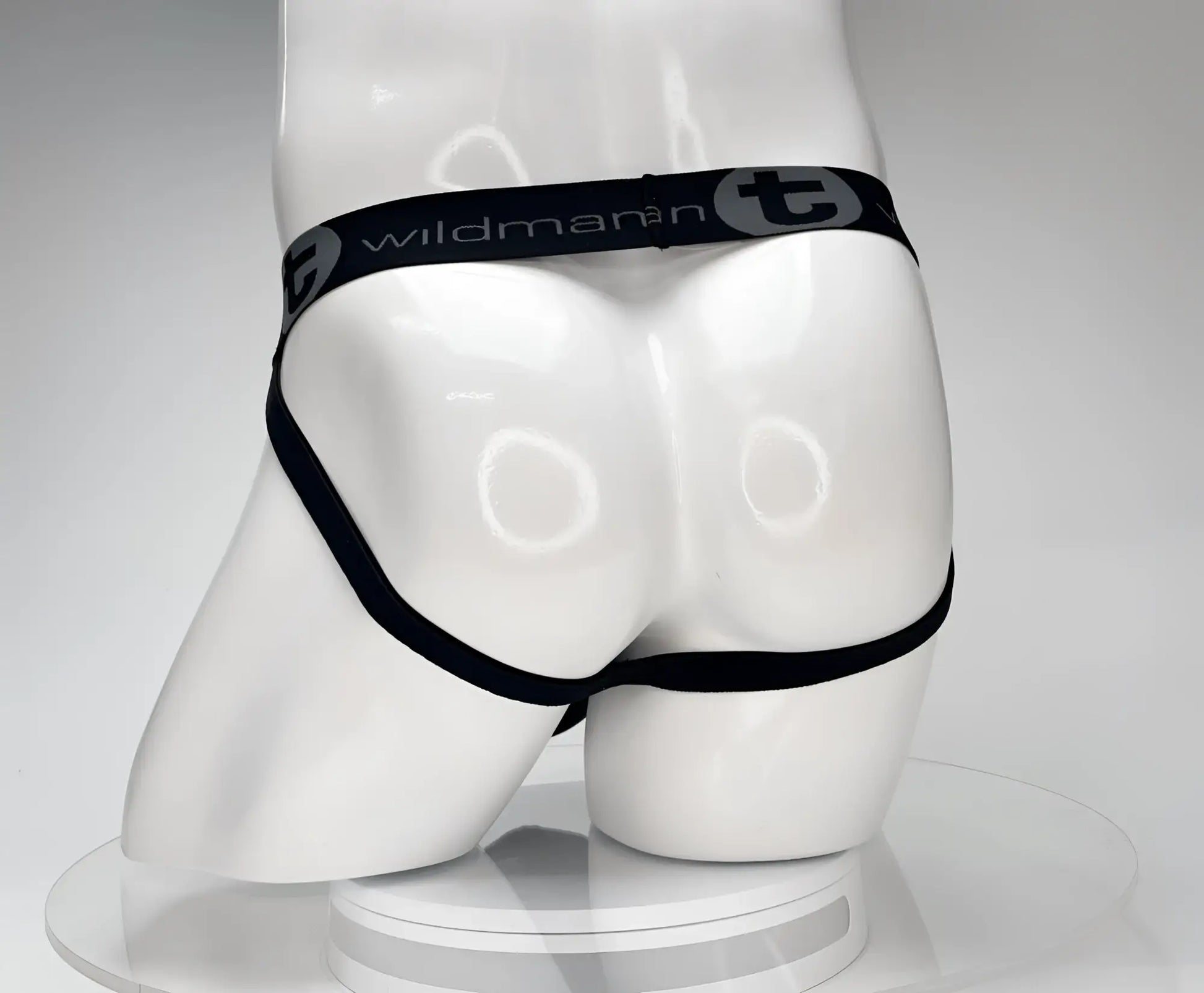 Black cotton jockstrap with wildman branded elastic waistband displayed on white mannequin