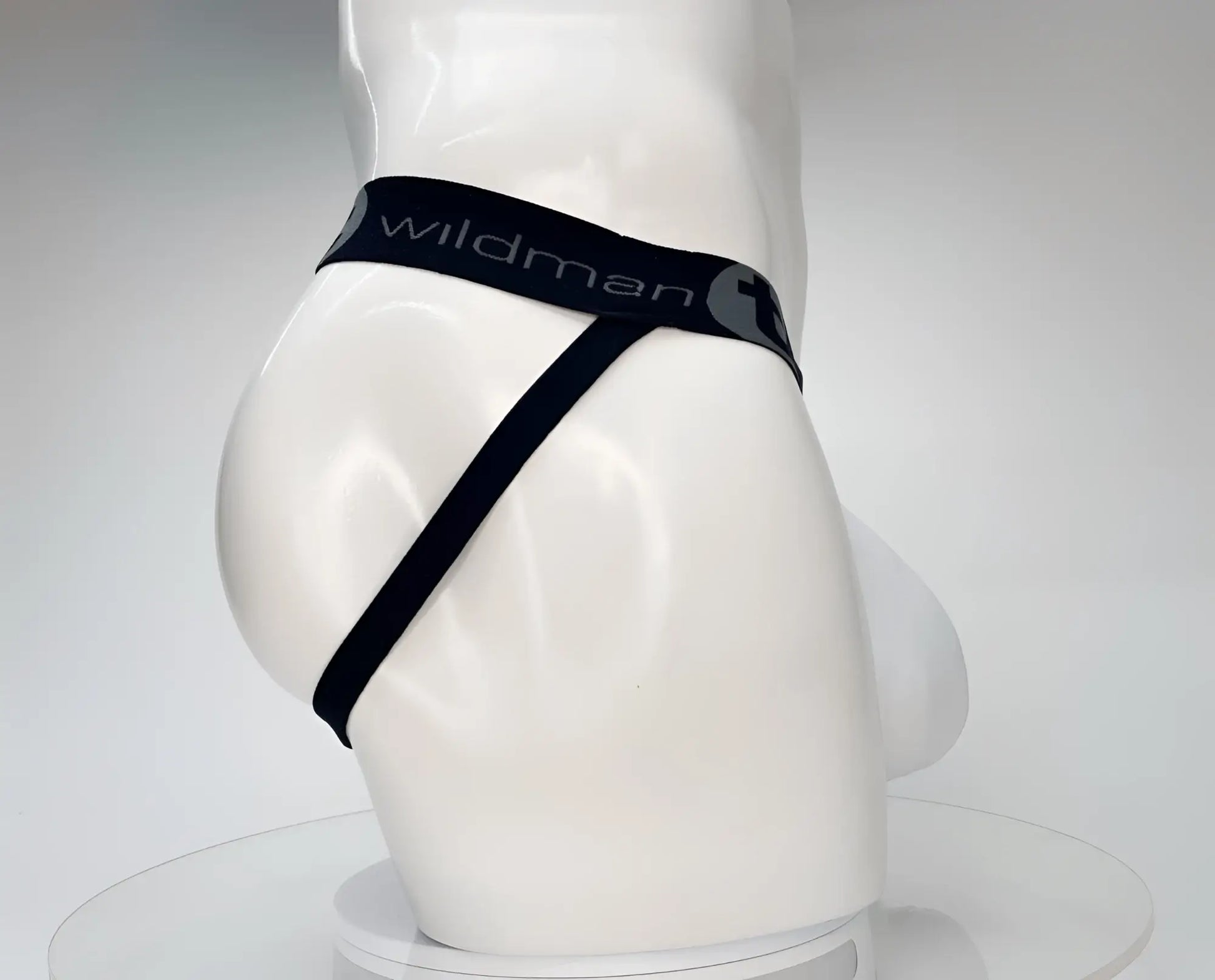Black wildman brand white cotton thong with sleek minimalist design and elastic waistband shown from the back side