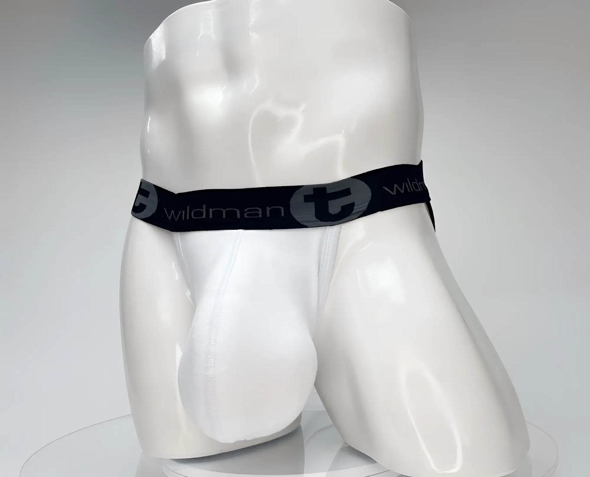 White men’s cotton briefs with black elastic waistband featuring wildman logo and stylized t emblem wildmant cotton monster cock jockstrap white