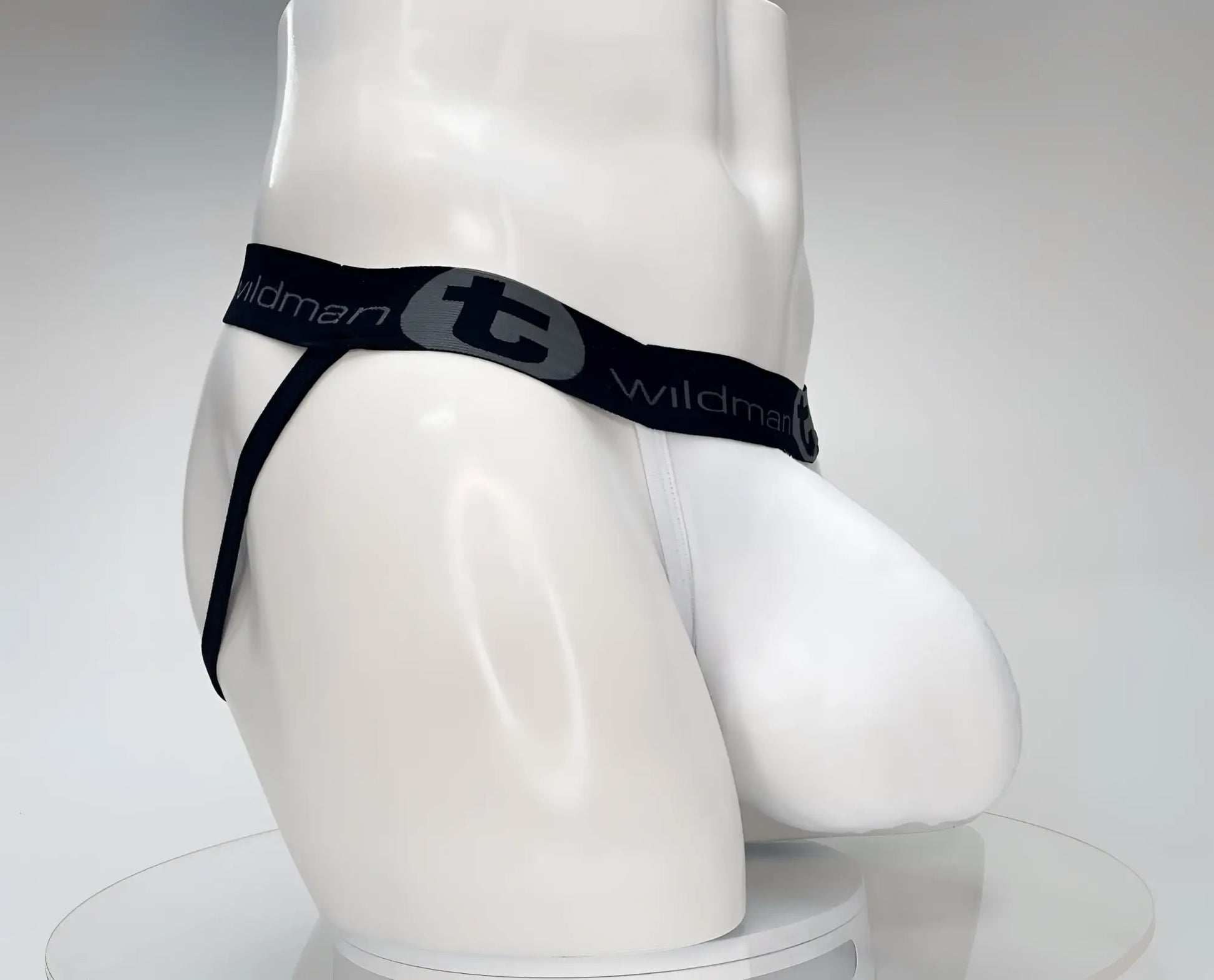 White men’s cotton thong with black elastic waistband and wildman branding featuring a gray logo