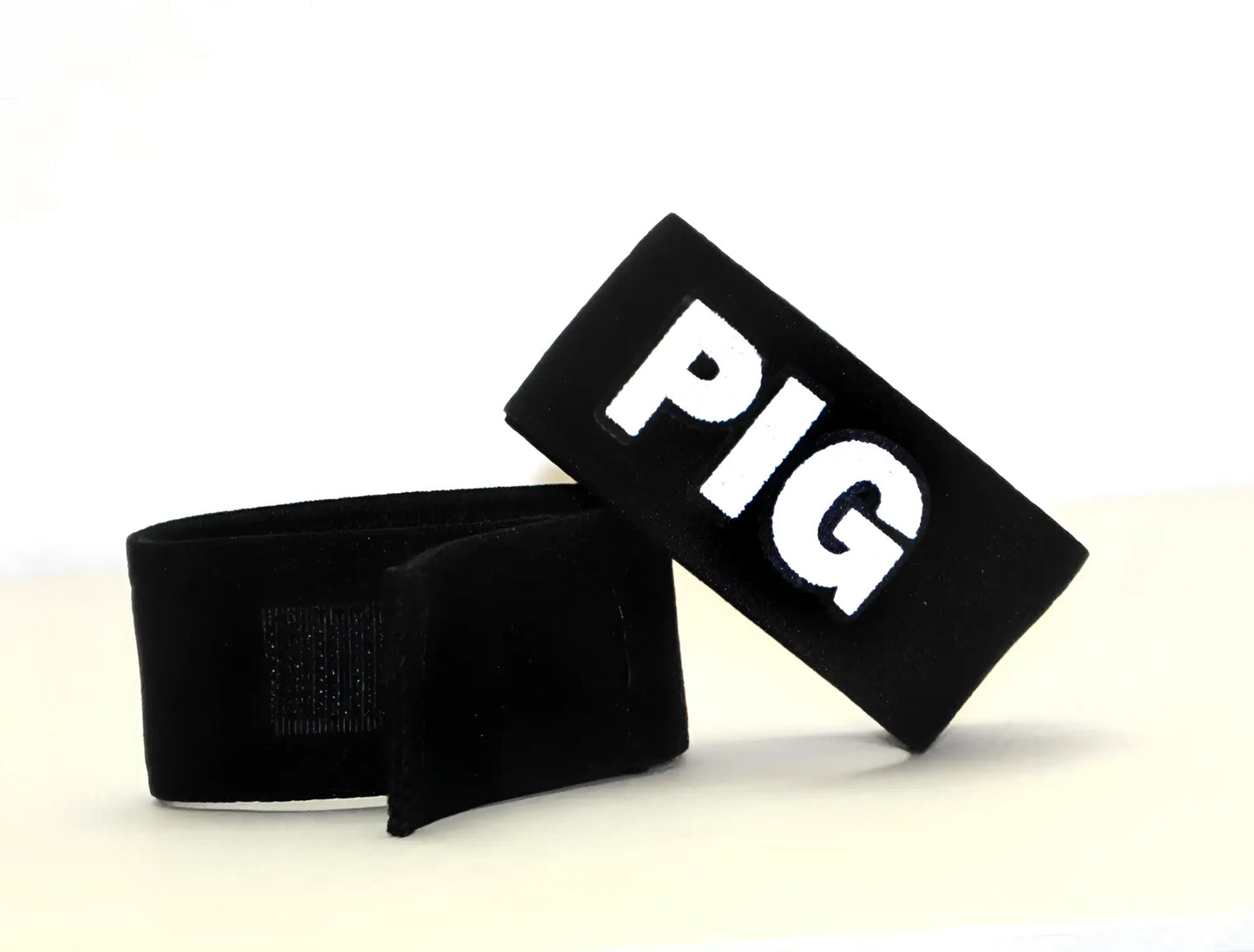 Black fabric wristband with white embroidered pig lettering part of wildmant fetish max cock-ring-pig accessory