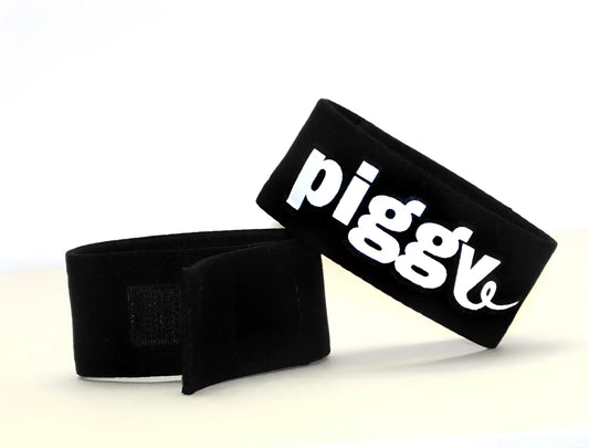 Black fabric wristband with white piggly logo featured on wildmant fetish max cock ring piggy product
