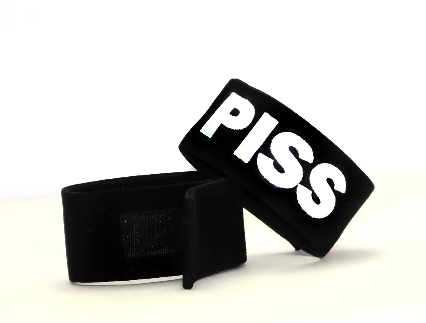 Black WildmanT fetish Max cock-ring wristband with bold white embroidered piss lettering on fabric band