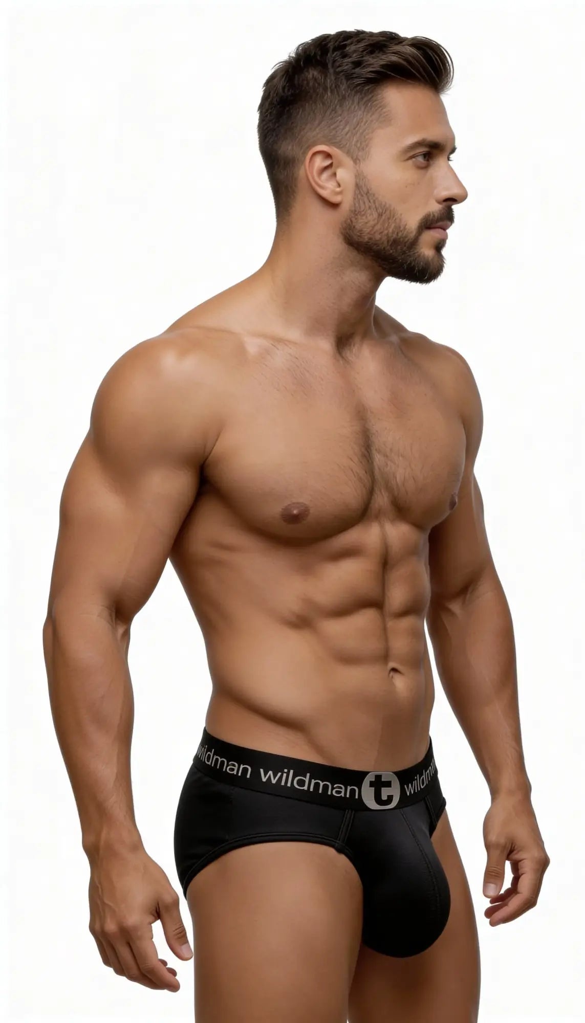 A muscular man wearing black mesh WildmanT Big Boy pouch briefs with a logo waistband, viewed from the side.