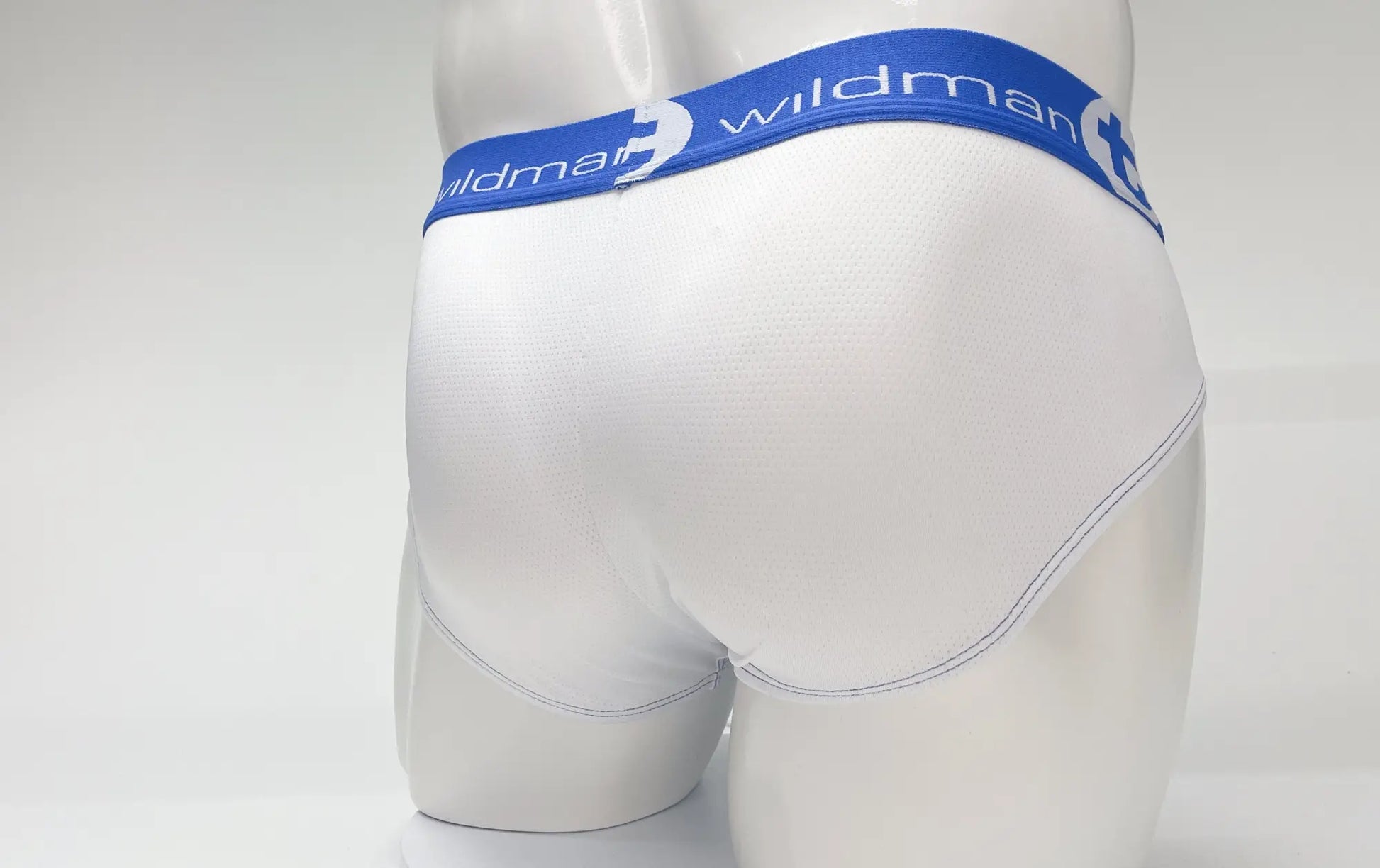 White wildman mesh big boy pouch briefs with blue elastic waistband featuring wildman logo and stylized w emblem
