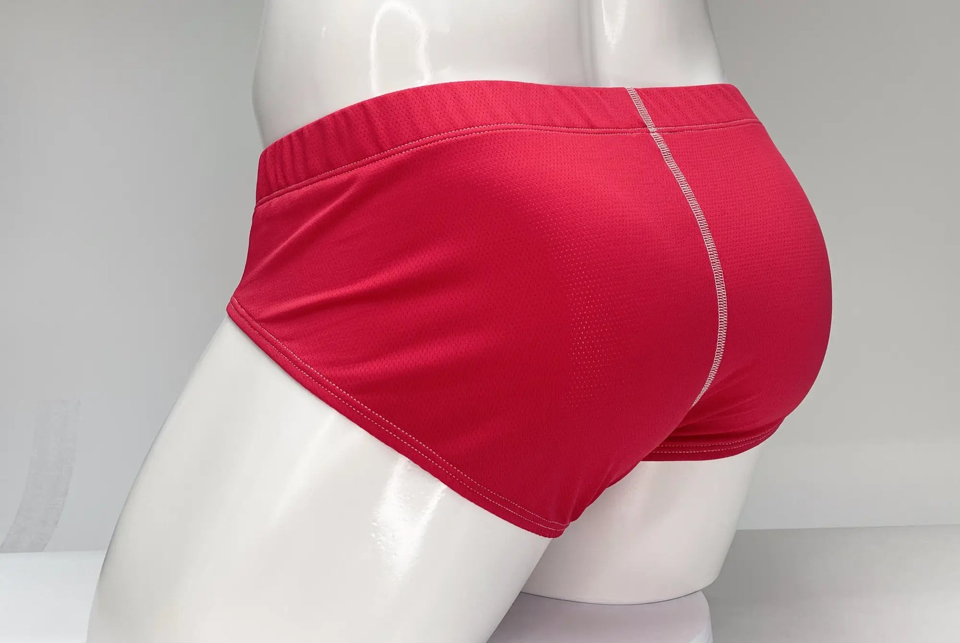 Red wildmant mesh brief featuring textured fabric and white stitching along the waistband