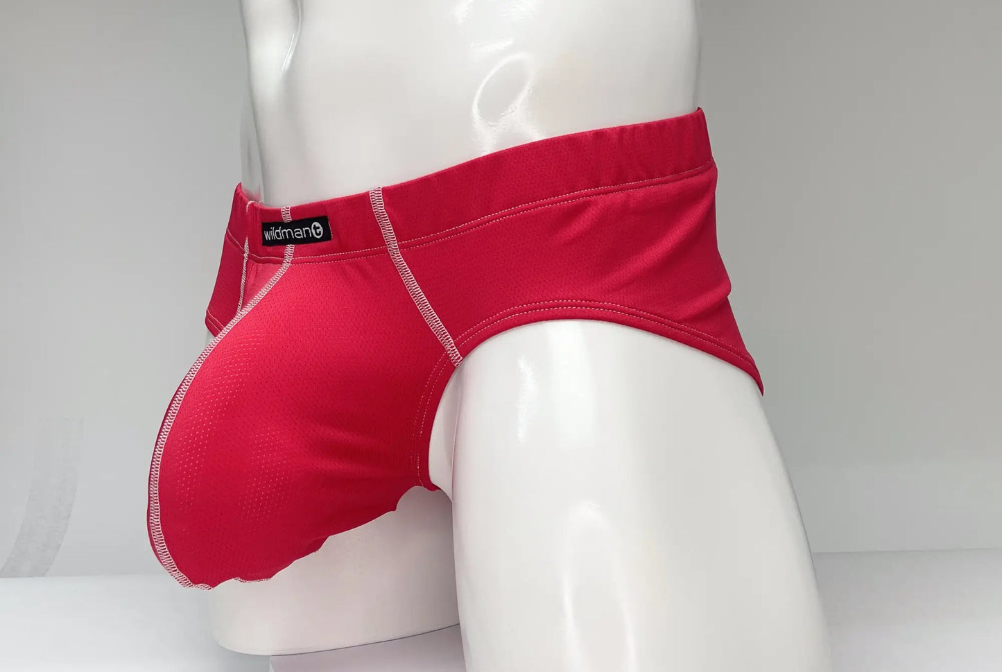 WildmanT mesh brief red bright red swim trunks with subtle textured pattern and white stitching on seams