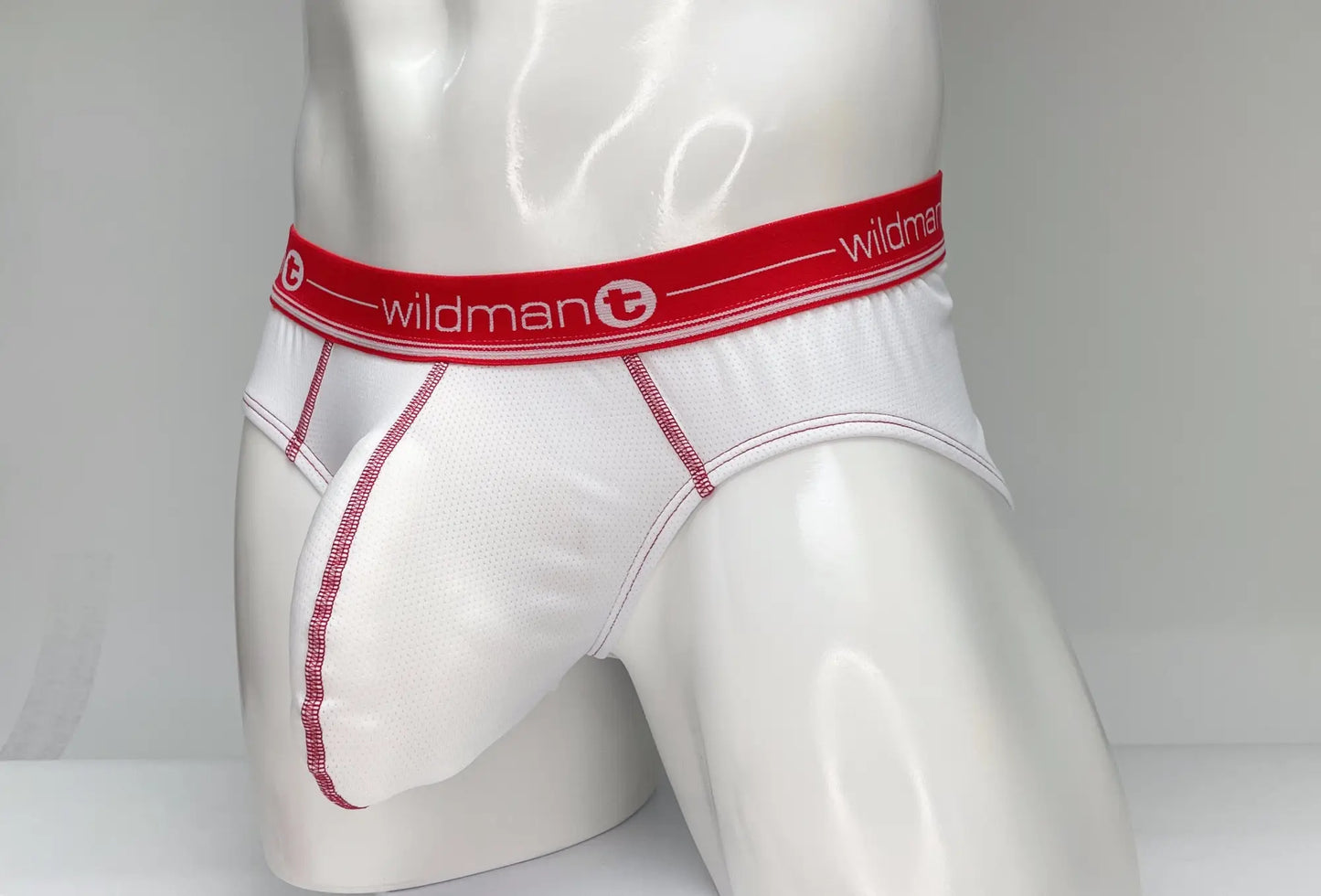 White men’s mesh briefs with red waistband wildman logo and pink stitching along seams in wildmant mesh brief white and red