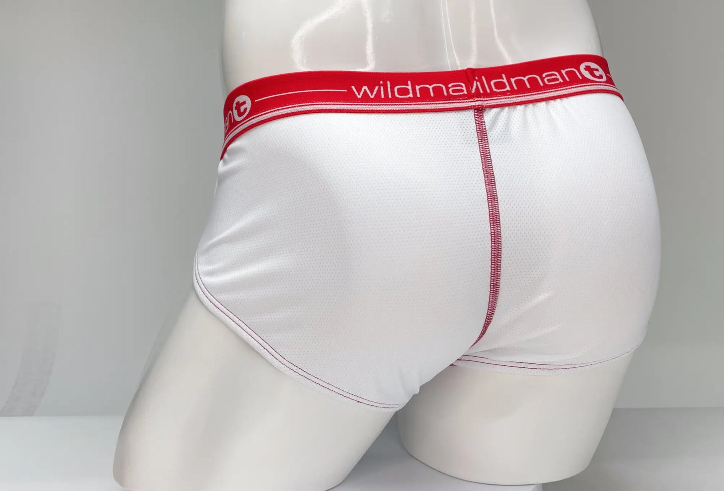 White mesh briefs with a red waistband featuring wildman brand name and logo for comfortable everyday wear